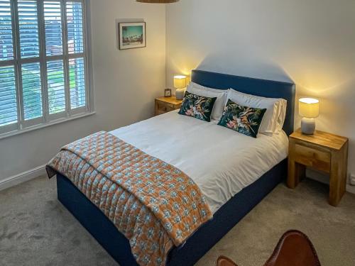 a bedroom with a bed with a blue headboard at Daisy Cottage in Sea Palling