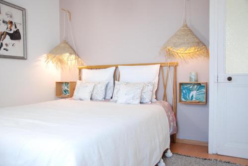 a bedroom with a bed with white sheets and pillows at Le Farniente, belle maison près du port in La Rochelle