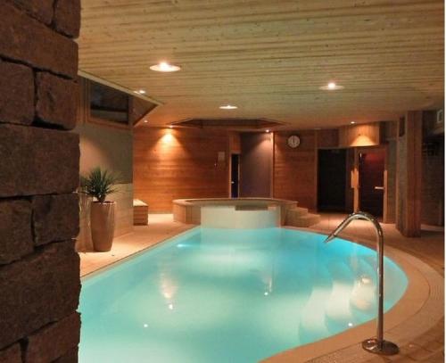 une grande piscine bleue dans un immeuble dans l'établissement Casa Bo, à Montgenèvre