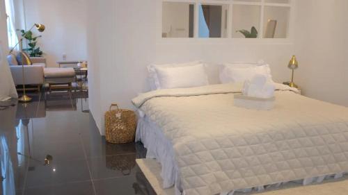 biała sypialnia z łóżkiem i salonem w obiekcie Luxury Loft Apartment w Kuwejcie