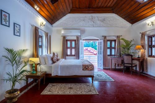 a bedroom with a bed and a desk in a room at ama Stays & Trails Skanda , Coorg in Madikeri