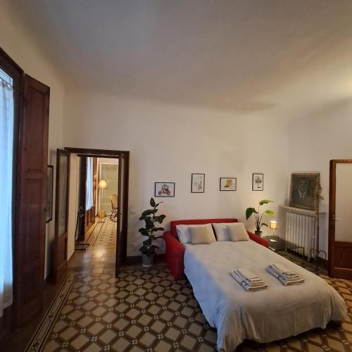 a bedroom with a large bed and a red couch at B&B Alice in Cremona