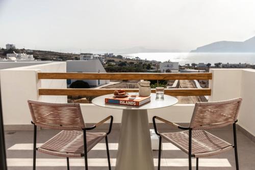 a table and chairs on a balcony with a view of the ocean at Nysis Koufonisia in Koufonisia