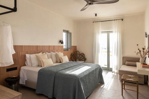 um quarto com uma cama e uma ventoinha de tecto em Nysis Koufonisia em Koufonisia