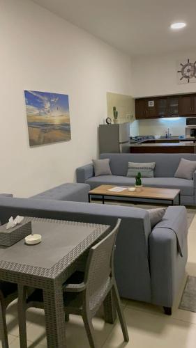a living room with a blue couch and a table at Golden Stone Beach in Halat Byblos