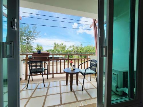 a balcony with a table and chairs and a view of the ocean at Lanta Mermaid Boutique House in Ko Lanta