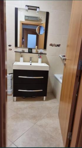 uma casa de banho com um lavatório e um espelho em Apartamento frente ao mar em Lavra