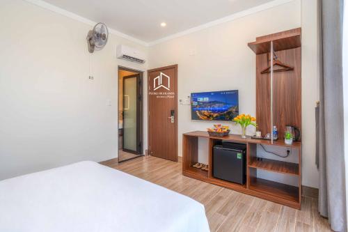 a bedroom with a bed and a desk with a tv at PLEIKU HIGHLANDS BOUTIQUE HOTEL in Plei Brel (2)