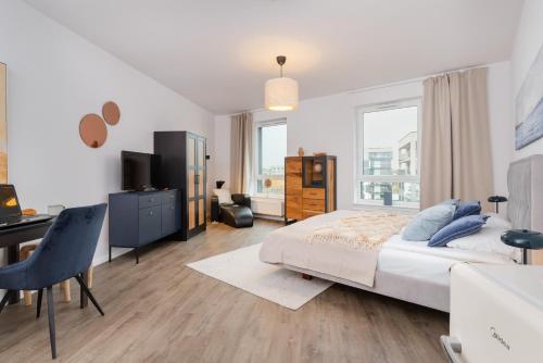 a bedroom with a bed and a desk with a computer at Śląska Studio with Parking & Gym Business District Gdańsk by Renters in Gdańsk