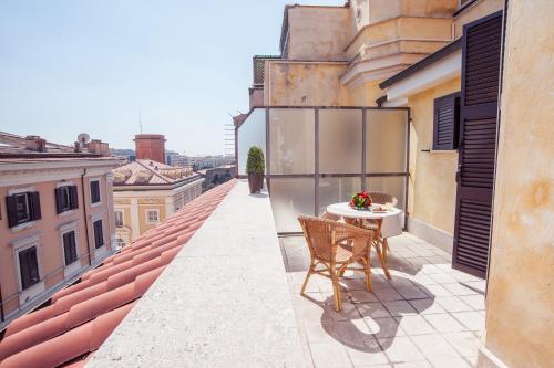 - un balcon avec une table et des chaises dans un bâtiment dans l'établissement Hotel Windrose, à Rome