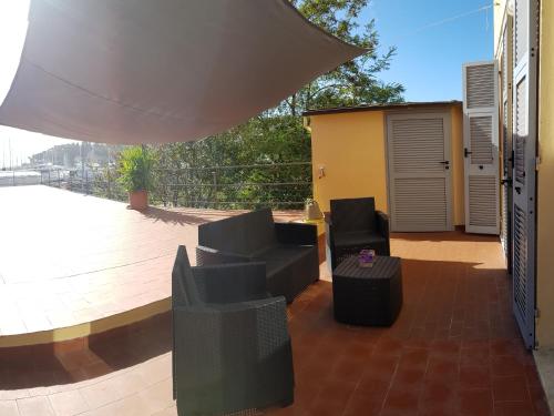 un patio avec deux chaises et une table sur une terrasse dans l'établissement La Terrazza Apartment,a 50 mt dal mare, à Varazze