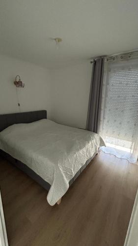 une chambre avec un lit et une fenêtre dans l'établissement Jolie T3 avec Parking, à Toulouse