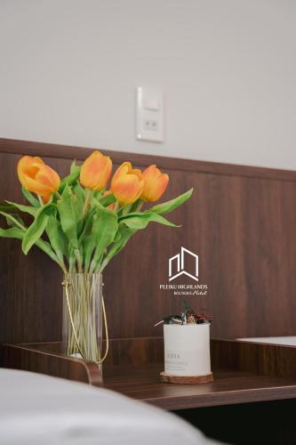 a vase of orange flowers sitting on a table at PLEIKU HIGHLANDS BOUTIQUE HOTEL in Plei Brel (2)