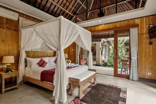 - une chambre avec un lit à baldaquin dans l'établissement Buana Tirta Ubud Villa, à Ubud