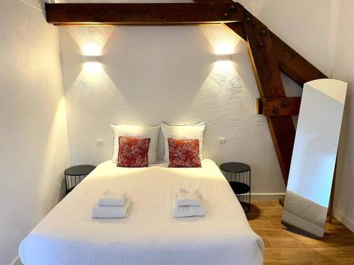 a bedroom with a white bed with two towels on it at Duplex Bord De Mer in Le Croisic