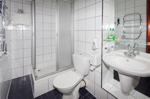 a bathroom with a toilet and a sink at Tauras Center Hotel in Palanga