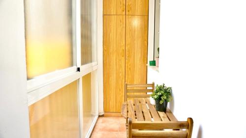 a hallway with a bench and a potted plant at Cervantes Prime in Valencia