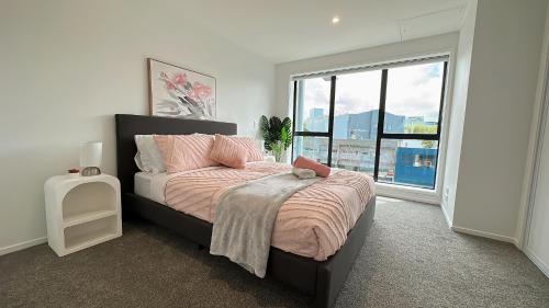 a bedroom with a bed and a large window at Walking Distance to Riverside Market & Hospital in Christchurch