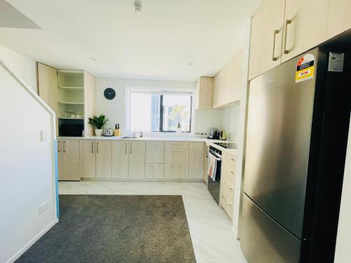 a kitchen with a stainless steel refrigerator and a window at Walking Distance to Riverside Market & Hospital in Christchurch