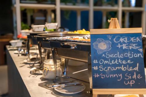 a row of trays of food on a buffet line at Ceylonz Leisure Suites KLCC Bukit Bintang in Kuala Lumpur
