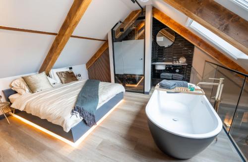 a bedroom with a bed and a bath tub at Boetiekhotel Faan in Ballum