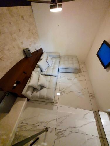 a living room with a couch and a television at VILLA MERIDA BOUTIQUE HOTEL - Adults Only in Mérida