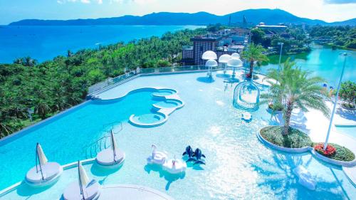HUALUXE Sanya Yalong Bay Resort في سانيا: منظر جوي لحمام سباحة في منتجع