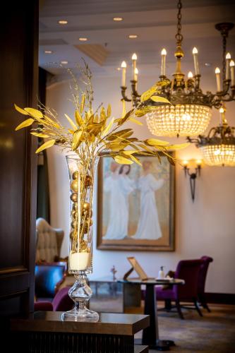 a vase filled with yellow flowers on a table at Esplanade Zagreb Hotel in Zagreb