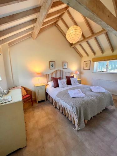 a bedroom with a large bed in a attic at The Calf Shed - cozy cottage in peaceful Norfolk countryside in Aldeby
