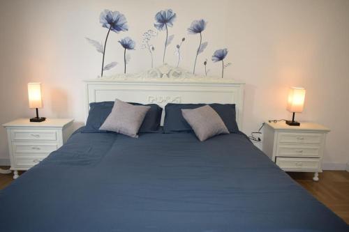 1 dormitorio con 1 cama azul y 2 mesitas de noche en MarcoPoloAirport-2 camere da letto-Wifi-Netflix-15' da Venezia en Tessera
