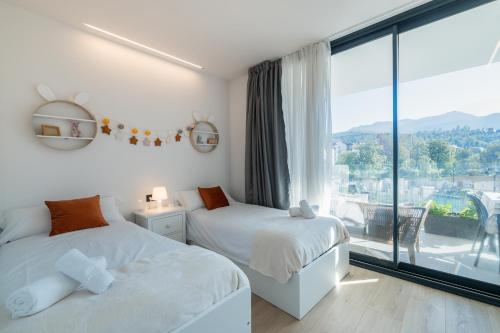 a bedroom with two beds and a large window at Riverview apartamento en LLanes in Llanes