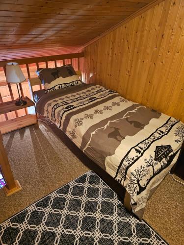 ein Schlafzimmer mit einem Bett in einem Holzzimmer in der Unterkunft L'ancien hospice in Bourg-Saint-Pierre