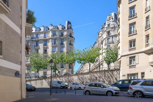 un groupe de voitures garées devant de grands bâtiments dans l'établissement Entire cozy apartment near Eiffel tower in Paris, à Paris