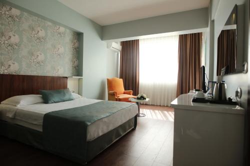 - une chambre avec un lit, un bureau et une télévision dans l'établissement Buyuk Saruhan Hotel, à Manisa