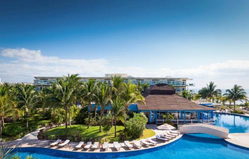 an aerial view of the resort with chairs and a swimming pool at Azul Beach Resort Riviera Cancun, Gourmet All Inclusive by Karisma in Puerto Morelos