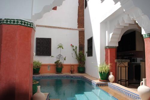 - une piscine dans un bâtiment avec des plantes dans l'établissement Riad Dar Palmyra, à Marrakech