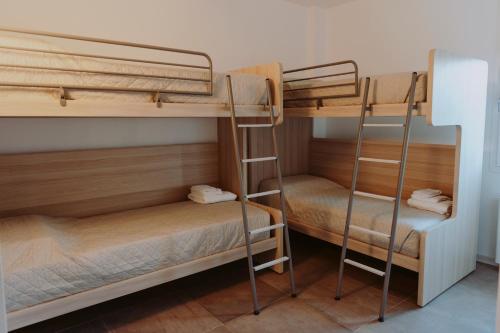 two bunk beds in a dorm room with a ladder at Antica Dimora dei Gelsi in Manerba del Garda