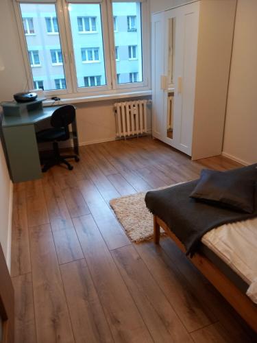 Habitación vacía con escritorio, cama y escritorio Sidx Sidx en Warta Piastowskie Apartament, en Poznan