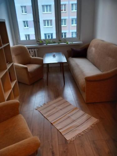 a living room with a couch and a coffee table at Warta Piastowskie Apartament in Poznań