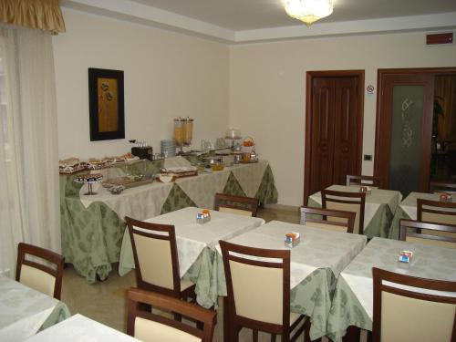 a dining room with white tables and chairs in a room at Hotel Le Palme in Gioia Tauro