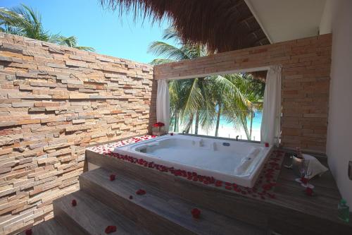 a large bath tub in a room with a window at Azul Villa Esmeralda - Gourmet All Inclusive by Karisma in Puerto Morelos