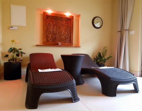 a room with two chairs and a clock on the wall at Apartmány Na Staré poště in Jimramov