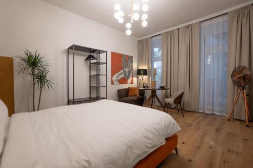 a bedroom with a large white bed and a desk at Stylish central 1-bedroom apartment with a terrace in Vienna