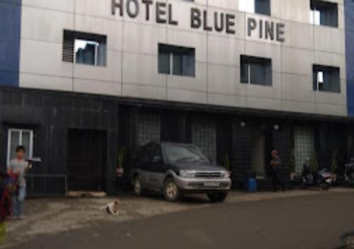 ein Auto, das vor einer blauen Kiefer des Hotels parkt in der Unterkunft Hotel Blue Pine Arunachal Pradesh in Itānagar
