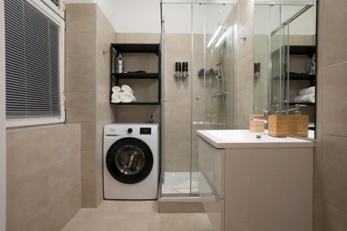 a bathroom with a washing machine and a sink at Stylish central 1-bedroom apartment with a terrace in Vienna