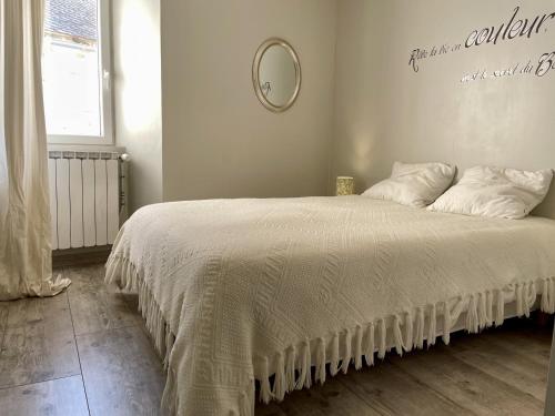 Connac的住宿－La Sebaline, superbe vue, vallee du Tarn，一间卧室配有一张带白色床罩和镜子的床