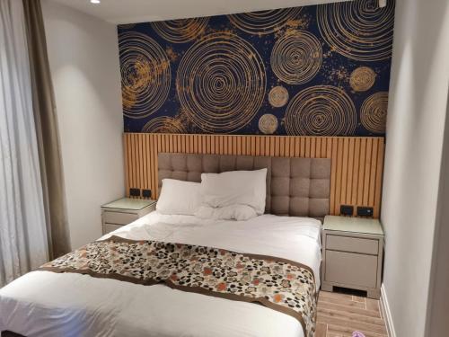 1 dormitorio con 1 cama grande y pared en מול החוף במלון רמדה נתניה en Netanya