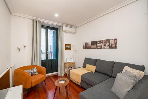 una sala de estar con un sofá y una silla en Céntrico Plaza España - Gran Vía II, en Madrid