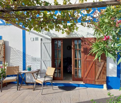 a patio with a table and chairs and a door at Hakuna matata in Benagil
