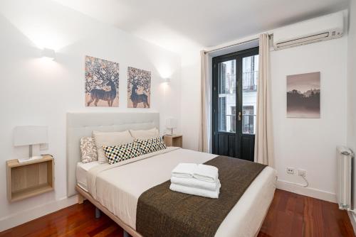 Un dormitorio con una gran cama blanca y una ventana. en Céntrico Plaza España - Gran Vía II, en Madrid
